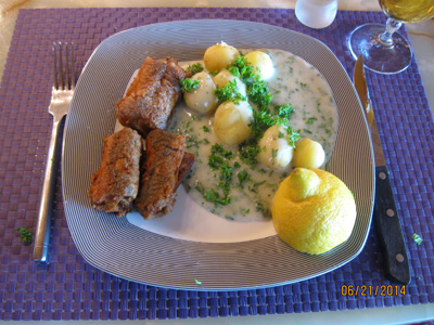 A portion of fried eel with cream stewed potatoes in parsley sauce, lemon, beer and a dram