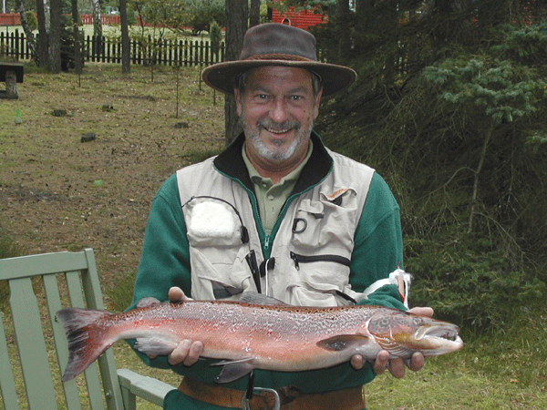Jørgen with a sea trout in a play suit from Stensån