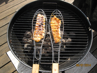 2 red fish fillets on the grill in a practical fish holder